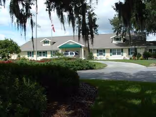 Exterior view of Pennbrooke Fairways senior living facility with driveway.
