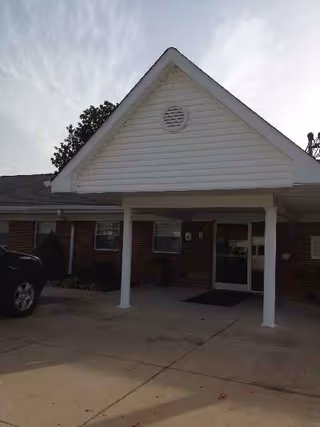 Front entrance of Laurelwood Health Care Center with brick exterior and covered drive.