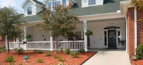 Brookdale Columbia exterior with a covered porch, white railing, and green front door.