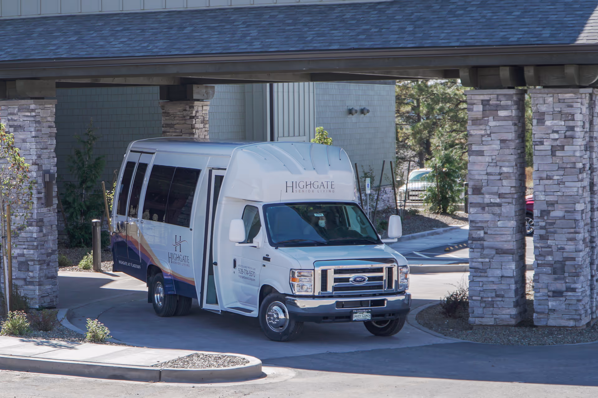 A Highgate Senior Living shuttle van parked under a covered entrance with stone pillars at the facility.