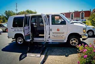 White Devonshire Oaks Nursing Center van with open doorway and wheelchair ramp in parking lot.