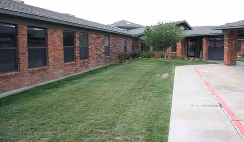 Exterior view of Hereford Nursing & Rehab with brick walls and green lawn.