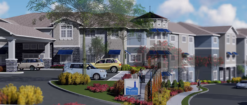 Exterior view of The Lodge at Glen Cove senior living facility showing a multi-story building with blue awnings, landscaped gardens, parked cars, and a sign with the facility name near the entrance.