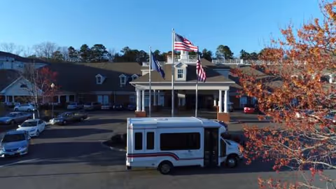 Front view of The Convalescent Center at Patriots Colony with a bus outside.