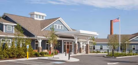 Exterior view of Hathorne Hill senior living facility with entrance canopy and parking.