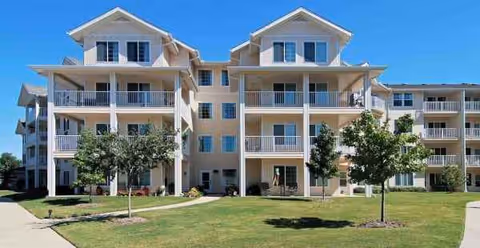 Exterior of Dogwood Estates Sky Active Living, a multi-story senior living building with balconies and lawn.