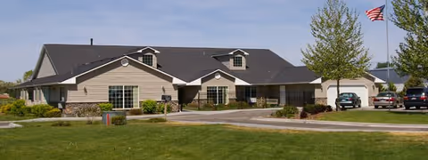 Exterior view of The Cottages Assisted Living and Memory Care-Mountain Home facility with parking.
