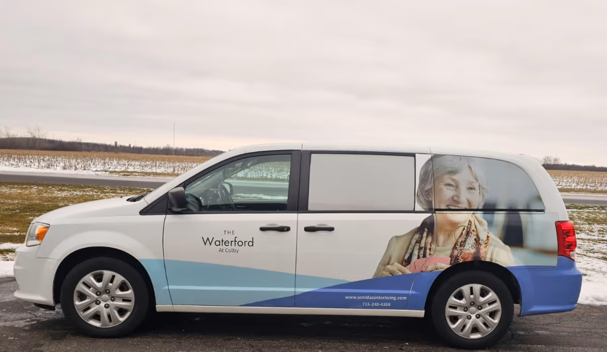 White Waterford at Colby promotional van with a large senior portrait on its side.