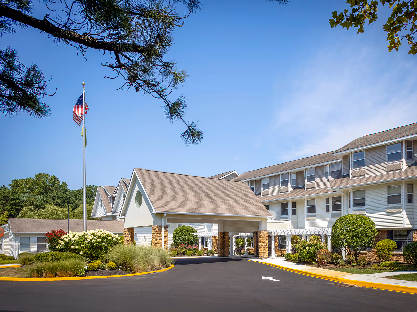 Atria Tinton Falls exterior with a covered entrance and landscaped driveway.