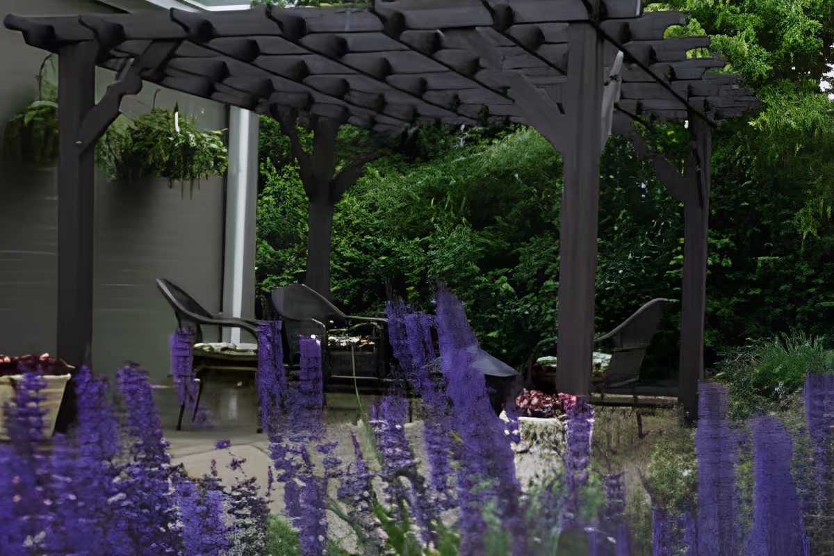 Outdoor patio with a wooden pergola, seating, and purple flowers in the foreground.