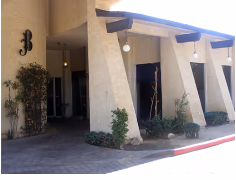 Exterior view of Best Care Adult Family Home entrance with columns and landscaping.