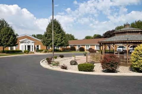 Exterior view of Hammond-Whiting Care Center with curved driveway and gazebo.