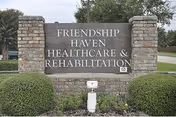 Brick entrance sign reading 'Friendship Haven Healthcare & Rehabilitation' flanked by shrubs and brick pillars.