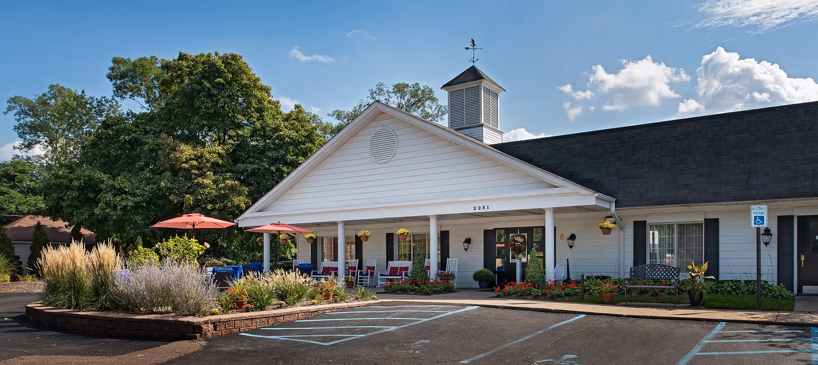 Exterior view of American House Elmwood with covered entrance and outdoor seating.