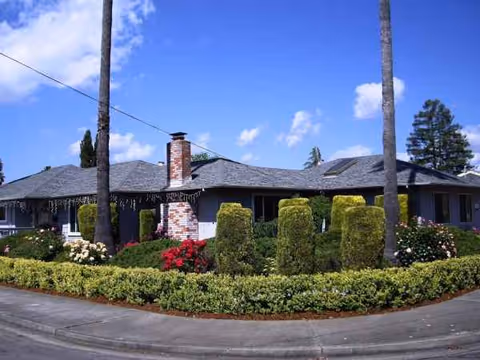 A single-story facility with manicured shrubs and a circular driveway at the front.