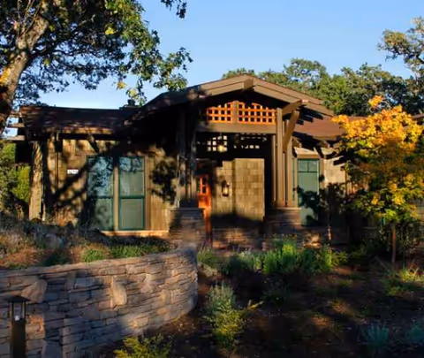 Exterior view of Fountaingrove Lodge illustrating its stone wall, entry stairs, and landscaped front yard.