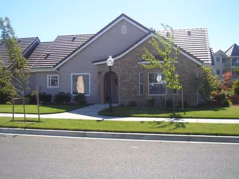 Front exterior of Countryside Village senior living building with a paved walkway and landscaping.