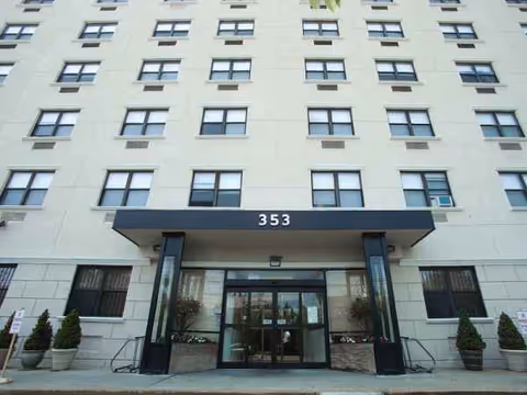 Facade of a multi-story senior care building with glass doors and a canopy at entrance.