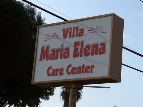 Outdoor sign reads Villa Maria Elena Care Center, with power lines and trees nearby.
