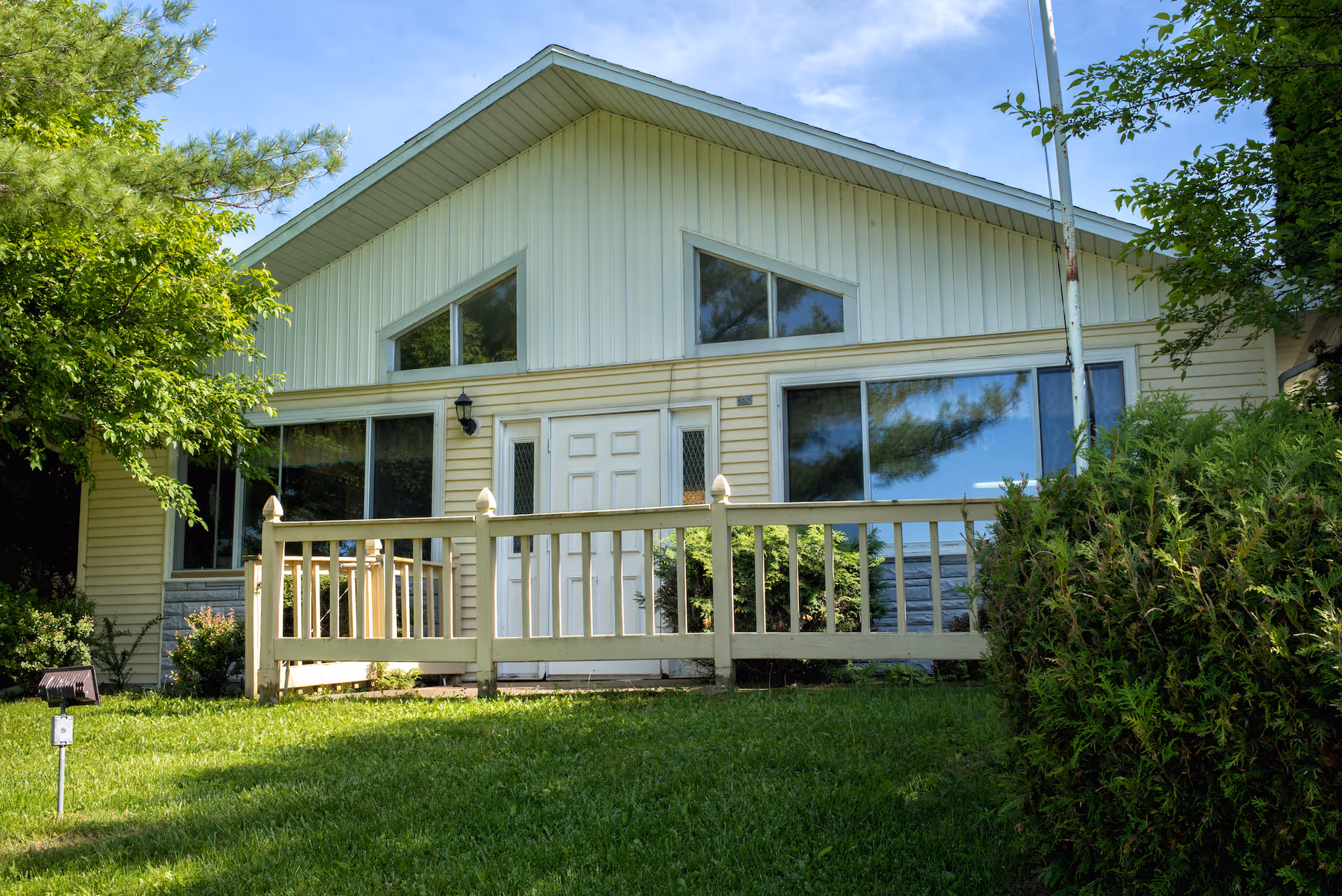 Front view of Harvest Guest Home exterior with a small porch and green lawn.