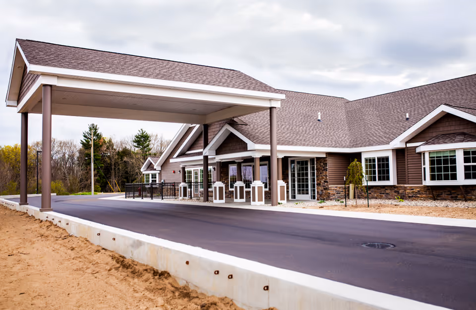 Exterior view of a senior living facility with a covered driveway and entrance.