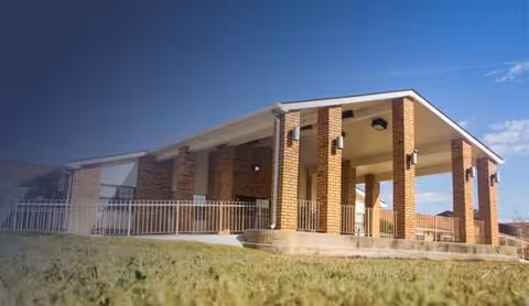 Exterior view of Bayside Healthcare Center entrance with brick columns and a covered porch.