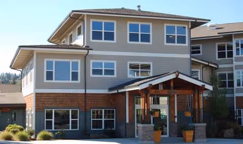 Exterior view of The Springs at Mill Creek entrance with a covered canopy and landscaping.
