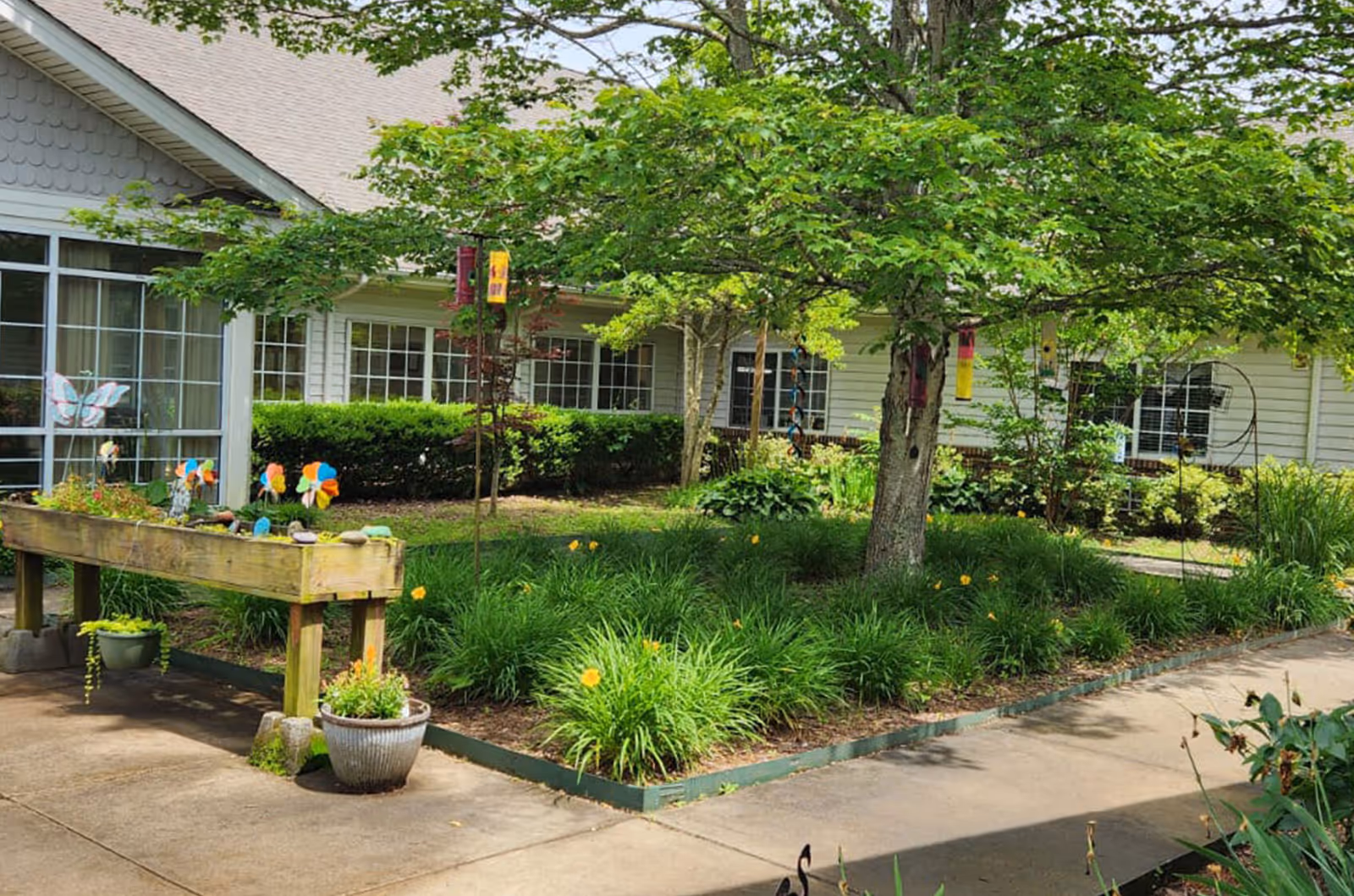 Exterior view of Fletcher Rehabilitation and Healthcare Center with greenery and walkway.
