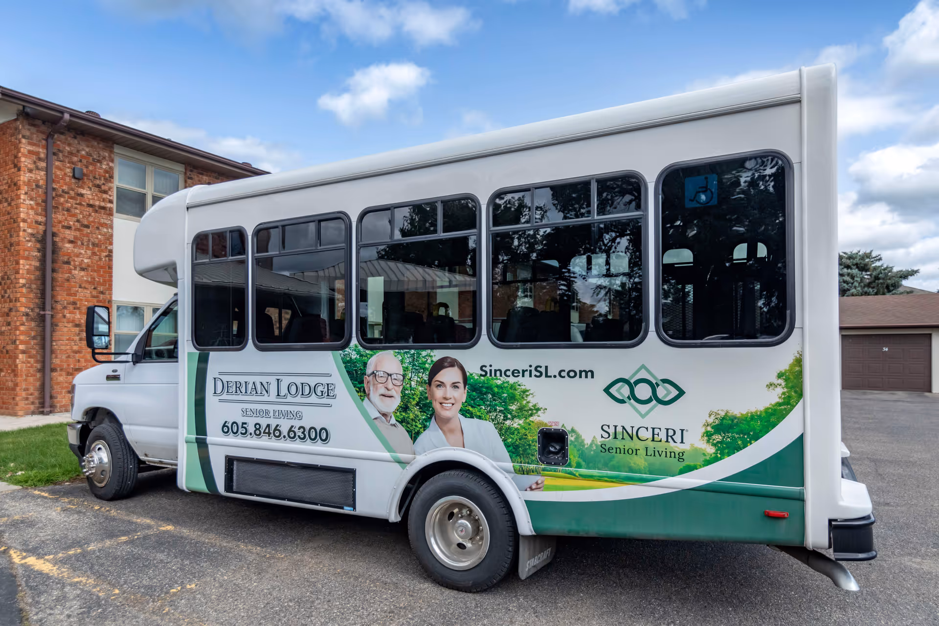 A Derian Lodge Senior Living shuttle bus parked outside a brick building with branding and phone number on its side.