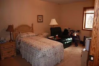 Two twin beds with floral bedspreads and a walker beside a dresser in a bedroom