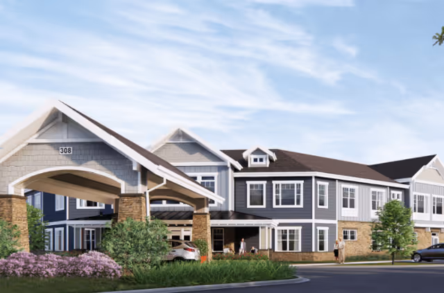 Exterior view of a two-story senior living facility with a covered entrance and landscaped front.