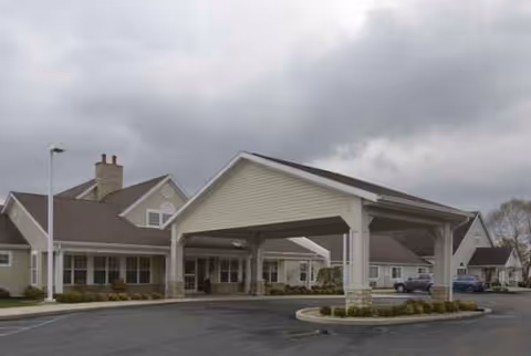 Exterior view of Carroll Place entrance with covered drop-off area and circular driveway.