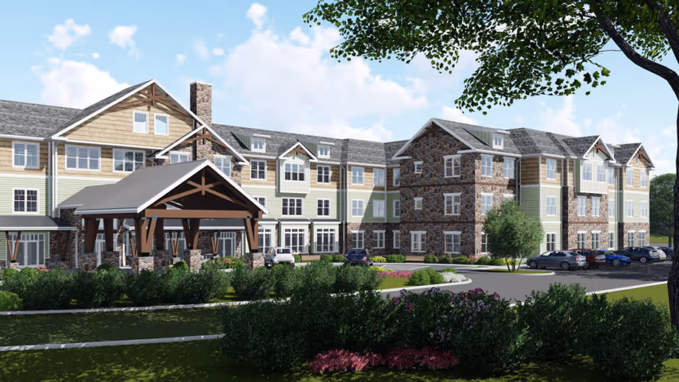 Front exterior rendering of a multi-story senior living building with a covered porte-cochere, landscaped grounds, and parked cars.