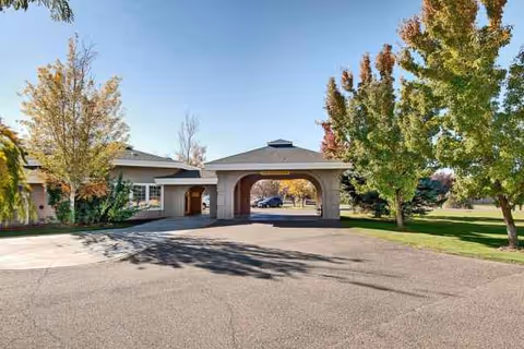 Exterior view of Wellsprings Assisted Living entrance with arched canopy.