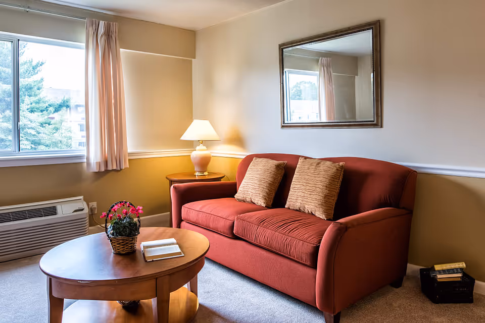 Cozy living room with red sofa, coffee table, and warm lighting.