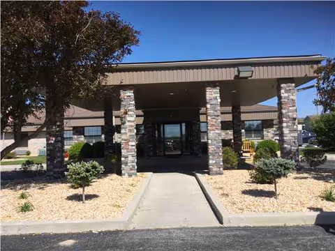Front entrance of a care center with stone columns and a walkway.