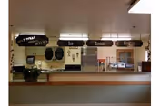 Interior dining area with a serving counter, chalkboard menus, and beverage station.