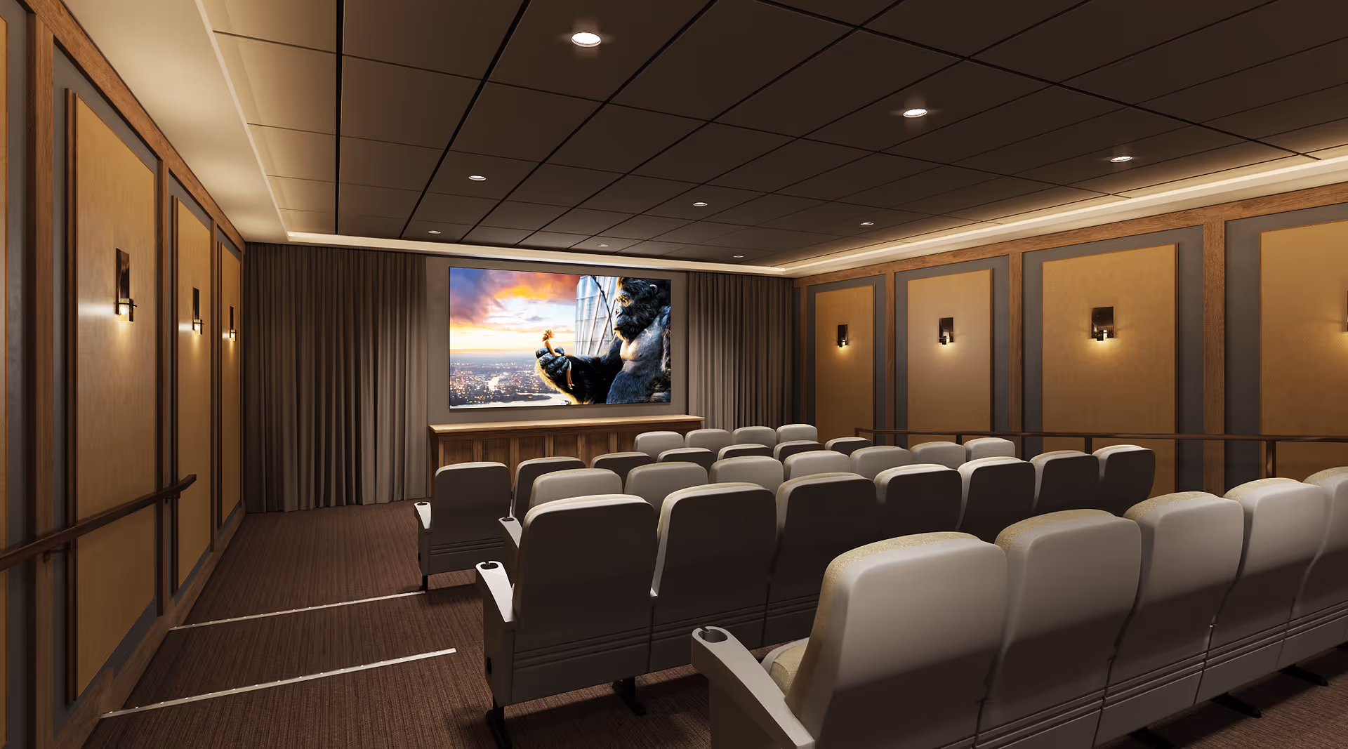 Interior view of a small theater room with rows of cushioned seats facing a large screen displaying an image of a giant gorilla holding a person with a cityscape in the background. The room has warm lighting, wood paneling on the walls, and a carpeted floor.