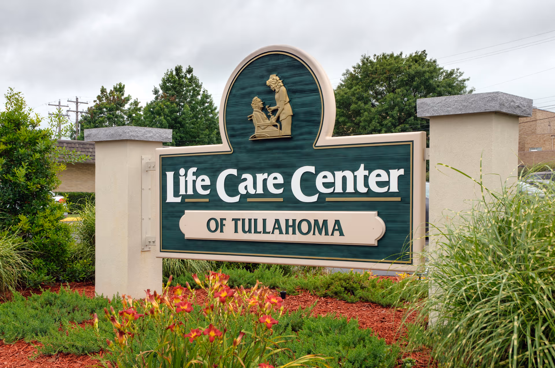 Outdoor entrance sign that reads "Life Care Center of Tullahoma" surrounded by landscaping.