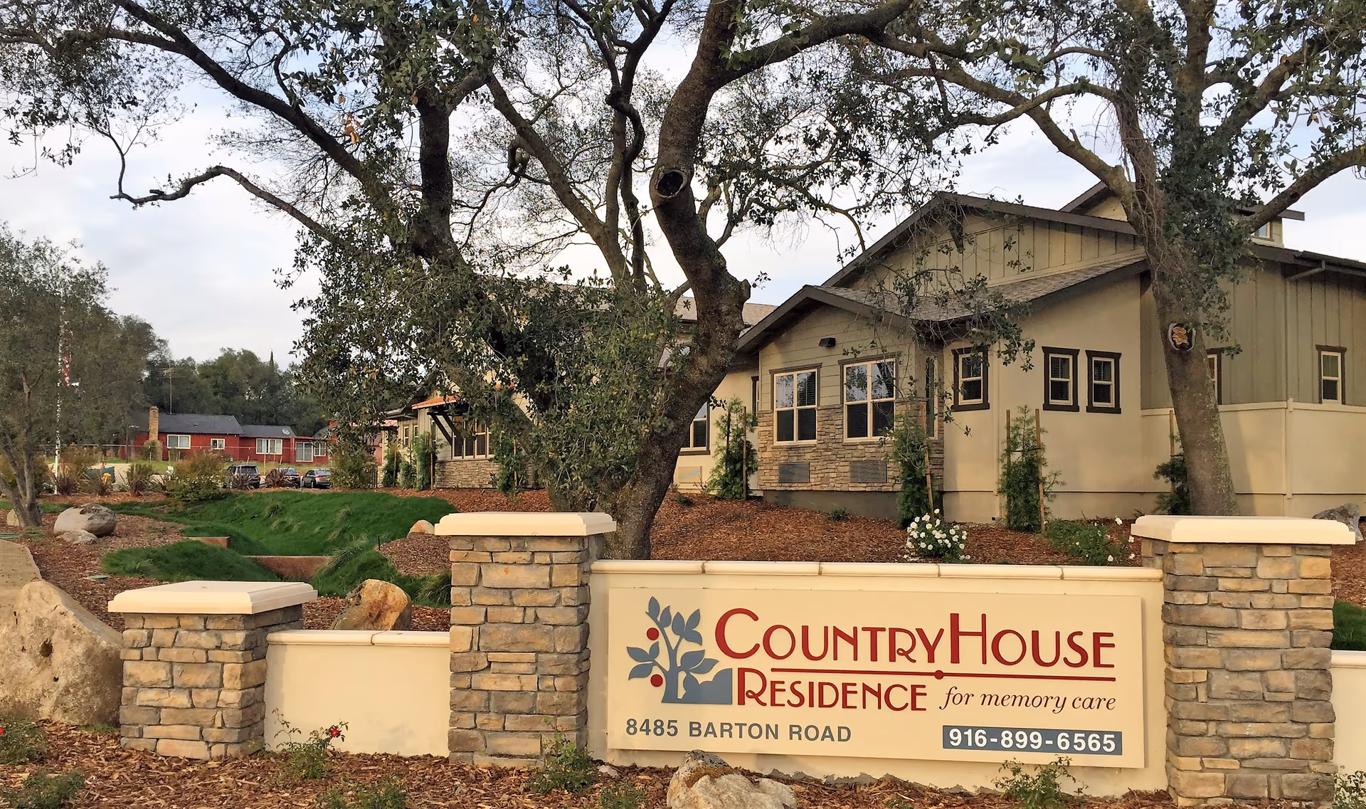 Exterior view of CountryHouse Residence sign and building entrance with trees