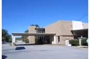 Exterior view of a beige retirement facility entrance with a canopy.