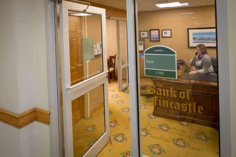 Interior of a senior living facility reception area with a bank-style desk.