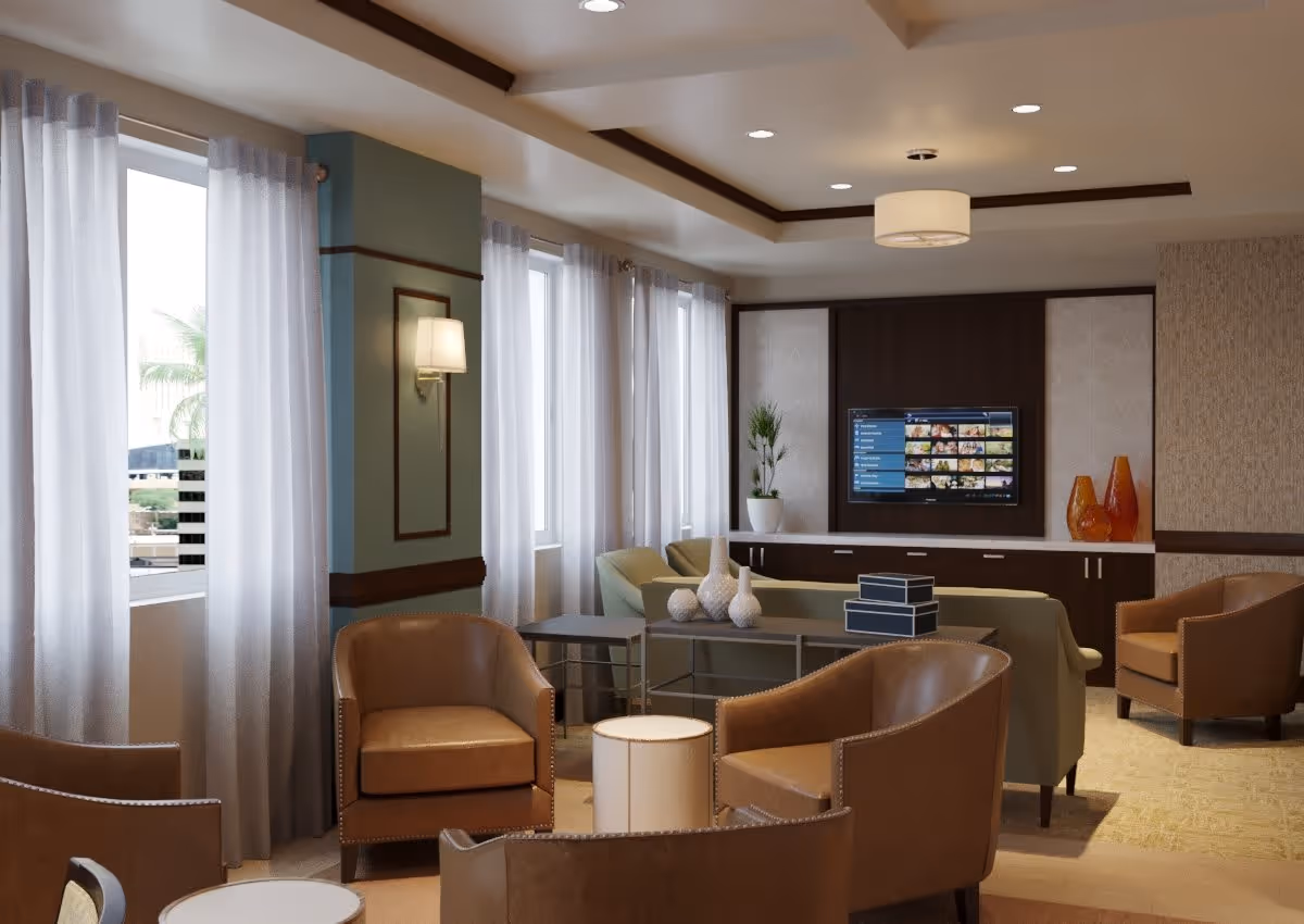 A modern living room area with brown leather armchairs, a green sofa, a glass coffee table with decorative vases, and a wall-mounted flat-screen TV. The room has large windows with sheer white curtains, soft lighting, and neutral-toned walls with wood accents.