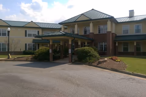 Front exterior view of The Haven at Columbus with a covered entrance, brick pillars, and landscaping.