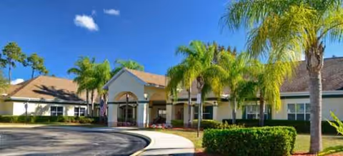 Exterior view of Brookdale Santa Barbara entrance with palm trees and landscaping.