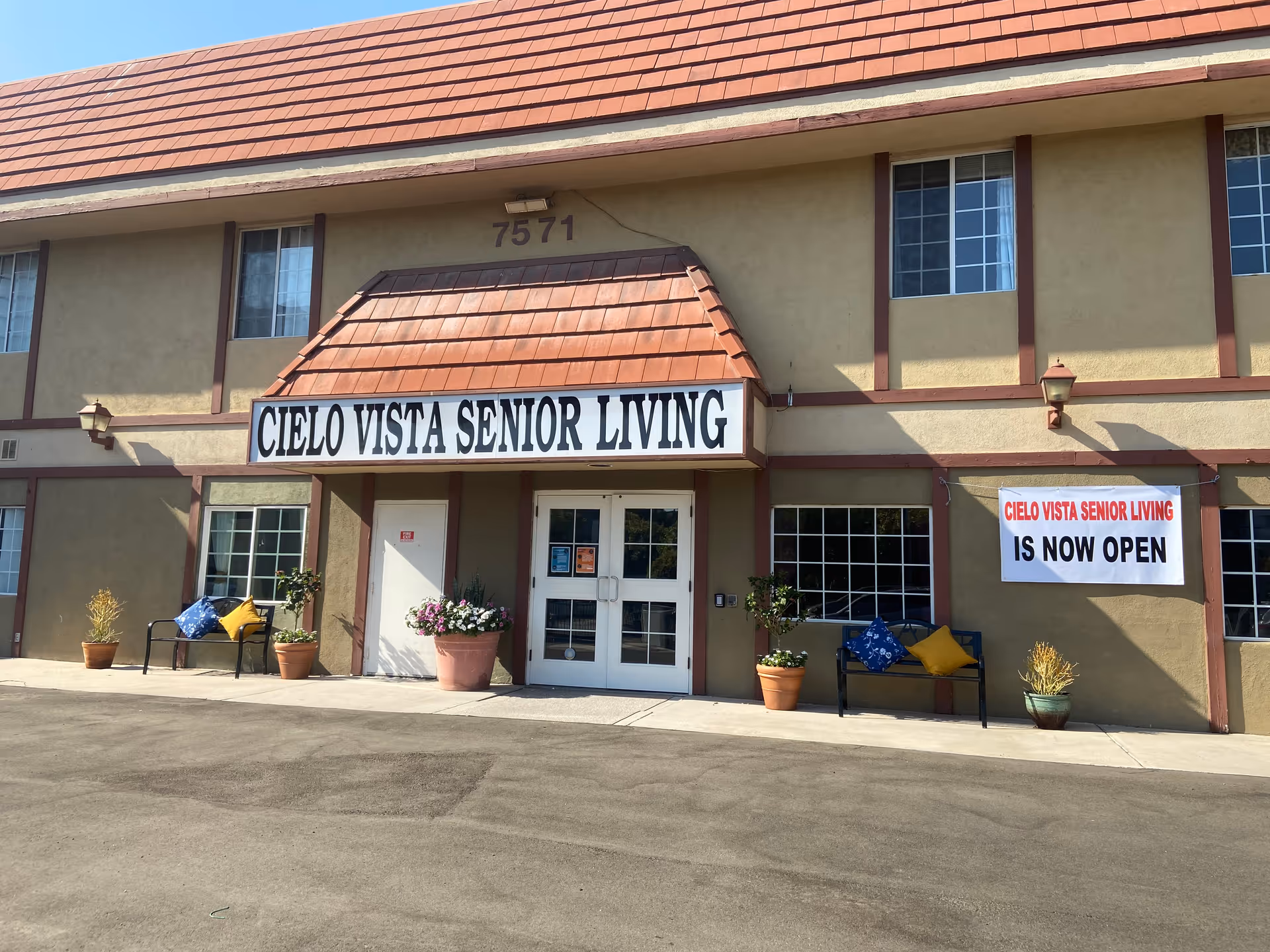 Front of Cielo Vista Senior Living with entrance, planters, and an 'Is Now Open' banner.