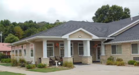 Exterior view of Anamosa Care Center building with a covered entrance and landscaped surroundings.