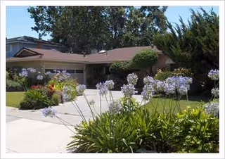 Bonhomie Assisted Care building with a landscaped front yard and blooming flowers.