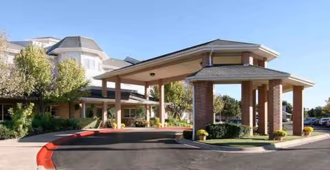 Polo Park Estates Sky Active Living exterior entrance with brick pillars and covered drop-off.