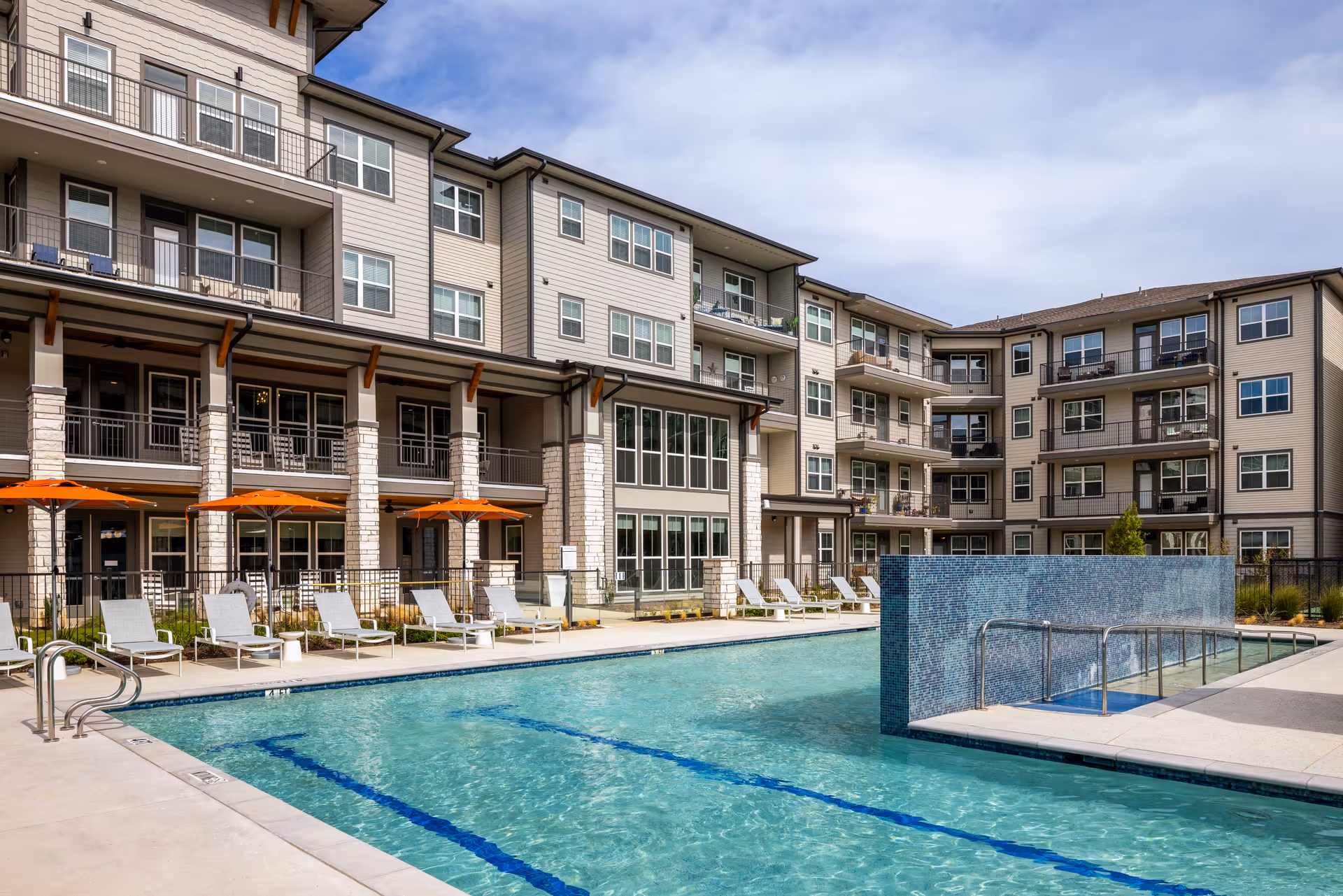 Exterior view of Solea Lewisville showing an outdoor pool and loungers